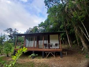 a cabin in the woods with a table and chairs at Cabana Manacá da Serra in Morretes