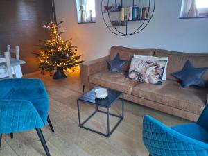 a living room with a couch and a christmas tree at La Maison des Senteurs in Francorchamps