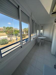 a room with windows and a table and a bench at Marina in Torrevieja