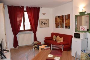 Una sala de estar con un sofá rojo y una mesa. en Casa Ischia, en Perugia