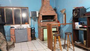 a kitchen with a stove and a brick fireplace at Morada do Altíssimo I in Uruguaiana