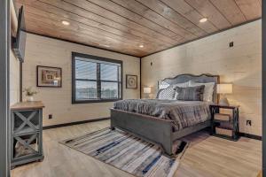une chambre avec un lit et un plafond en bois dans l'établissement Smith Creek Resort- 5 Bedroom 20 Guests - Indoor Pool - Resort Amenities, à Sevierville 55 autres photos