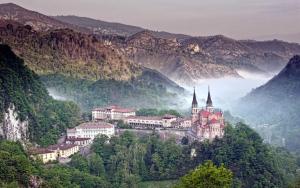 ein Schloss auf einem Hügel mit Bergen im Hintergrund in der Unterkunft Apartamento Rural Lago Ercina in Cangas de Onís