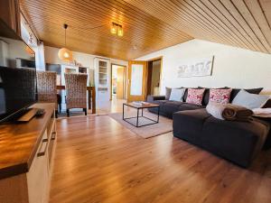 a living room with a couch and a table at BerglerNest - Apartment mit Bergblick! in Bihlerdorf