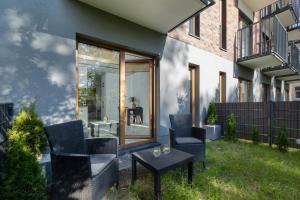 een patio met stoelen en een tafel voor een gebouw bij Apartament Vip - Studio - Silverforest 69 in Szczecin +3 foto's