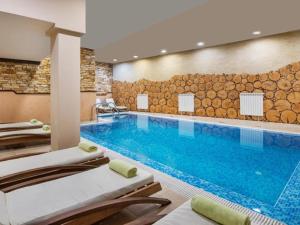 a pool in a hotel room with lounge chairs at Snowflake Family, Parking, SPA option, 600mbps in Bansko