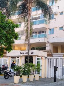 里约热内卢Alugo Suítes de luxo - Parque olímpico的停在一座棕榈树建筑前面的摩托车