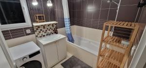 a small bathroom with a sink and a washing machine at Chambre accueillante in Prévessin