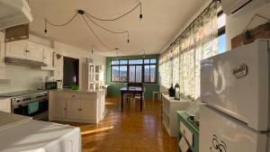 a kitchen with white cabinets and a table in it at Refúgio dos Mauzinhos in Ourondo