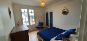 une chambre avec un lit, un bureau et une fenêtre dans l'établissement Le Crépuscule, 300m de la plage, animaux de compagnie bienvenue, à Gouville-sur-Mer