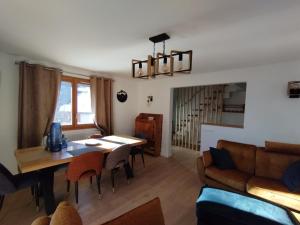 a living room with a table and a couch at La Terrasse des Ecrins in Saint-Martin-de-Queyrières