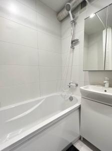 a white bathroom with a tub and a toilet at City Center Apartment in Narva +18 photos