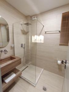Un baño con ducha con puerta de cristal. en Ea's Luxury Apartments Korca, en Korçë 15 fotos más