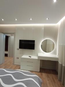 1 dormitorio con TV y espejo en Ea's Luxury Apartments Korca, en Korçë