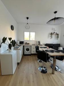 a kitchen with white appliances and a table with chairs at Le nid douillet de Clermont ferrand in Clermont-Ferrand +11 photos