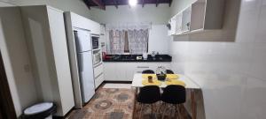 a small kitchen with a table and two chairs at Casa no centro aproveite o melhor de Foz in Foz do Iguaçu