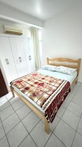 a bedroom with a bed with a blanket on it at Pousada Altos dos Ingleses II in Florianópolis