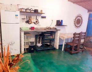 a kitchen with a table and water in the floor at Casinha Guiné MorroSP in Morro de São Paulo