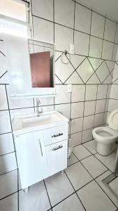 a white bathroom with a sink and a toilet at Pousada Altos dos Ingleses II in Florianópolis
