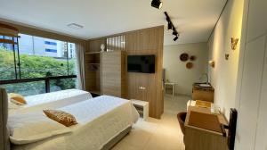 a hotel room with two beds and a television at Nô Centro Suítes Florianópolis 1 in Florianópolis