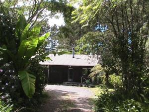 a house in the middle of a yard with trees at Cosy Unit 3 bdrms Two dogs live onsite with me in Waipapa