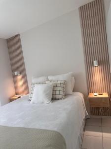 a bedroom with a white bed with two night stands at Elegant Modern Tiny Home in San Miguel