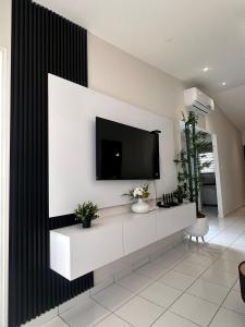 a living room with a tv on a wall at Elegant Modern Tiny Home in San Miguel