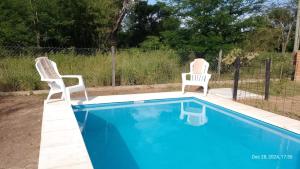 two chairs sitting next to a swimming pool at Dos Eucaliptus in Villa Rumipal