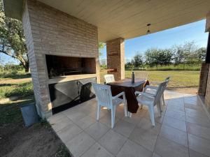 a patio with a table and chairs and a fireplace at Dos Eucaliptus in Villa Rumipal