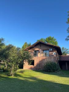 una vecchia casa di mattoni in un cortile alberato di Casa completa con piscina y quincho en Ascochinga, 4 habitaciones, zona golf a Ascochinga