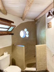 a bathroom with a toilet and a window at Casa LaMora in San Marcos Sierras