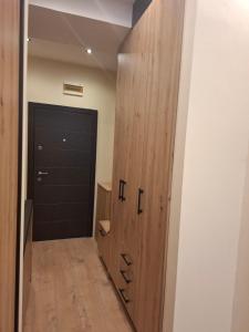 a hallway with a black door and a wooden closet at Planinska Tajna in Zlatibor +19 photos