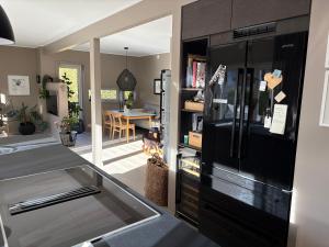 eine Küche mit einem schwarzen Kühlschrank und einem Esszimmer in der Unterkunft Modern & cozy house in Trondheim
