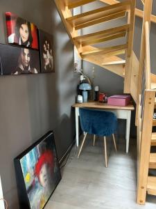 Zimmer mit einem Schreibtisch und einer Treppe mit einem blauen Stuhl in der Unterkunft Modern & cozy house in Trondheim