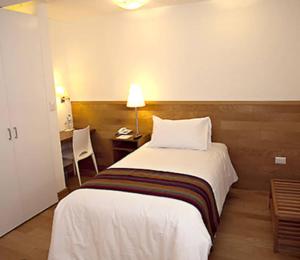 a bedroom with a bed and a desk with a lamp at Apartamento encantador in La Victoria
