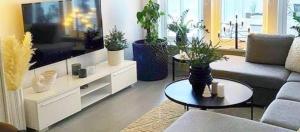 a living room with potted plants and a large tv at Apartamento encantador in La Victoria