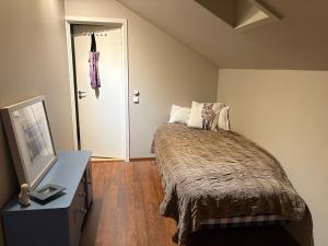 ein Schlafzimmer mit einem Bett, einer Kommode und einem TV in der Unterkunft Modern & cozy house in Trondheim