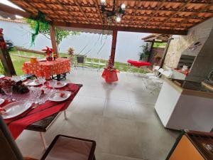 a dining room with a table with a red table cloth at Casa da Dinda à 650m da praia de Itaúna in Saquarema +6 photos