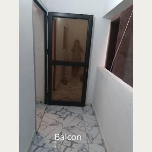 een deur in een gang met een weerspiegeling van een persoon bij Fôhundi home in Abidjan +2 foto's