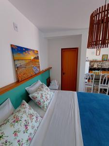 a bedroom with a bed with pillows on it at Maresia in Passo De Torres