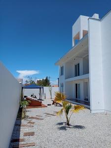 a building with a gazebo and a boat on a beach at Maresia in Passo De Torres +14 photos