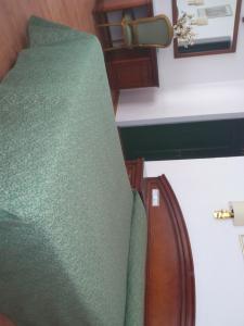 a green chair in a room with a counter at Hotel Cardinal in Albacete