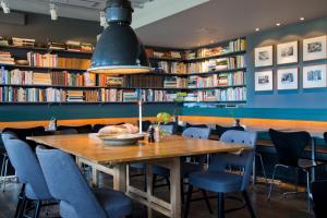 a dining room with a wooden table and bookshelves at Mornington Hotel Bromma in Stockholm