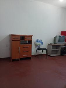 a room with a desk and a tv and a chair at Kitnet Inteira São P da Aldeia in São Pedro da Aldeia