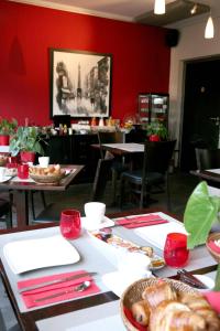 a dining room with red walls and tables and chairs at Hotel La Villa Julia in Agon-Coutainville
