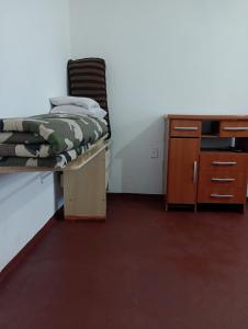 a bedroom with a bed and a desk and a chair at Kitnet Inteira São P da Aldeia in São Pedro da Aldeia