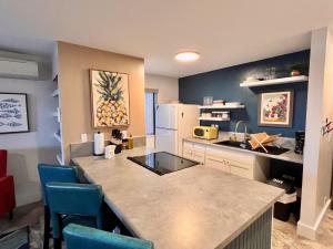 cocina con encimera y sillas azules en Holualoa Gardens 104, en Kailua-Kona 7 fotos más