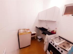 een kleine keuken met een koelkast en een fornuis bij Casinha Guiné in Morro de São Paulo