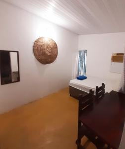 een kamer met een bed, een tafel en een spiegel bij Casinha Guiné in Morro de São Paulo