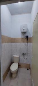 a bathroom with a toilet and a box on the wall at Villa Highland No 8 UU Berastagi View in Berastagi +25 photos